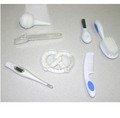 Kit contents: brush, comb, thermometer, nail clipper, measuring spoon, suction bulb, and recalled pretzel shaped teether
