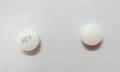 This is an image of two small white round pills of Olanzapine 2.5 milligram tablets 100. Starting from the left, the pill has OZ2.5 in blue ink written on it. The pill on the right is blank.