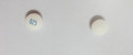 Ceci est une image de deux petites pillules blanches d'Olanzapine 5 milligramme comprimés 100. À la gauche, la pillule a l'inscription OZ5 en encre bleue sur la pillule. La pillule à la droite n'a aucune inscription.