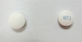 This is an image of two small white round pills of Olanzapine 7.5 milligram tablets 100. On the right, the pill has OZ7.5 in blue ink written on it. The pill on the left is blank.