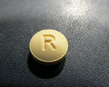 This is an image of two small round yellow pills of Ondansetron 8 milligram tablets. The pill has the letter R encrusted in it.