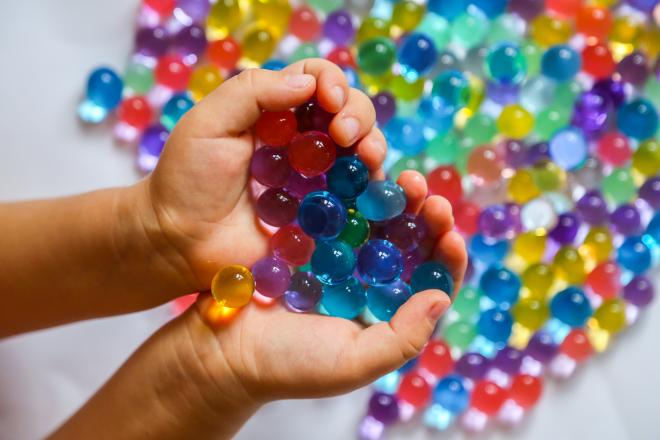 Colored water beads in child's palms